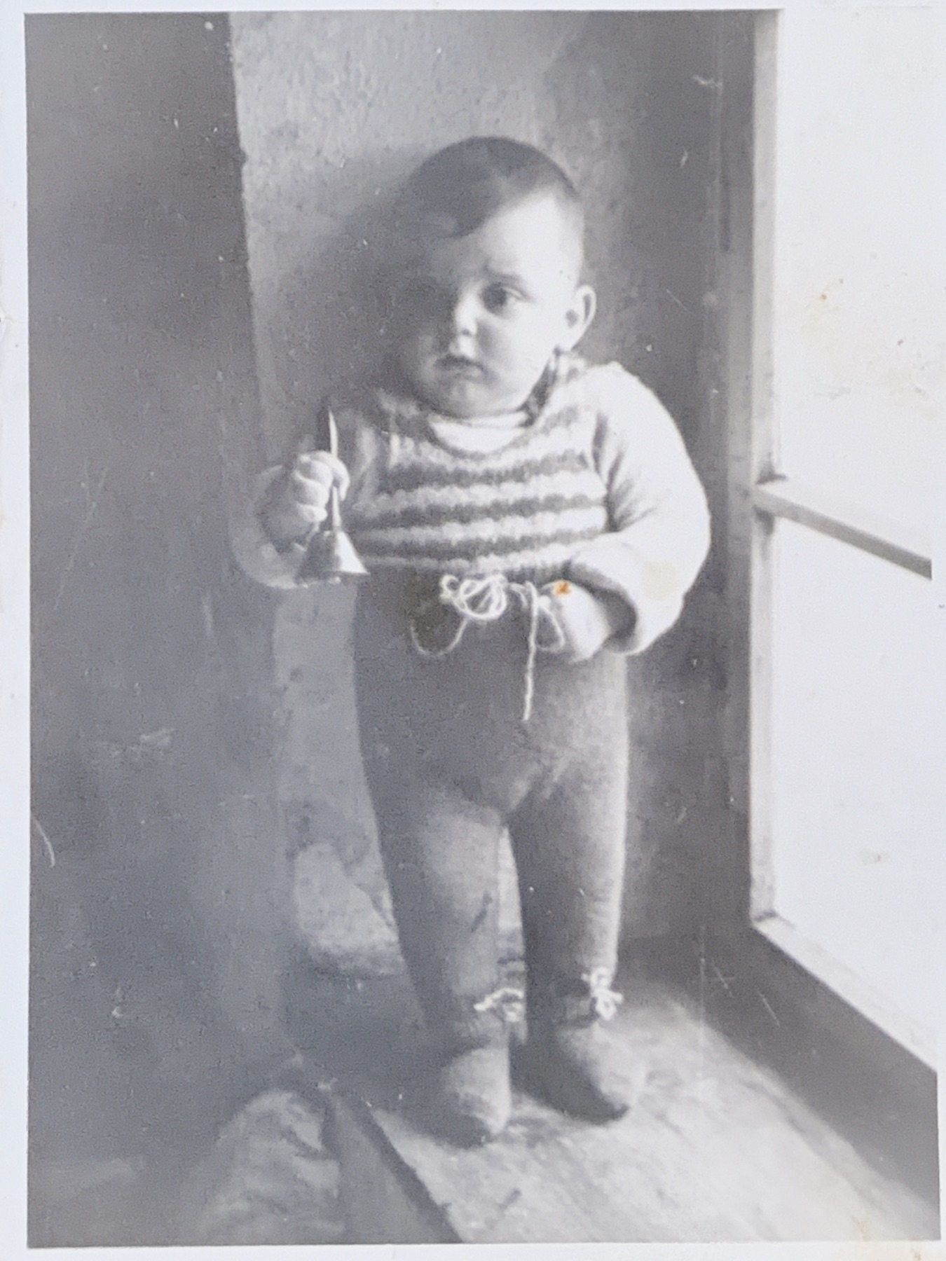 Morris as a toddler standing near a window